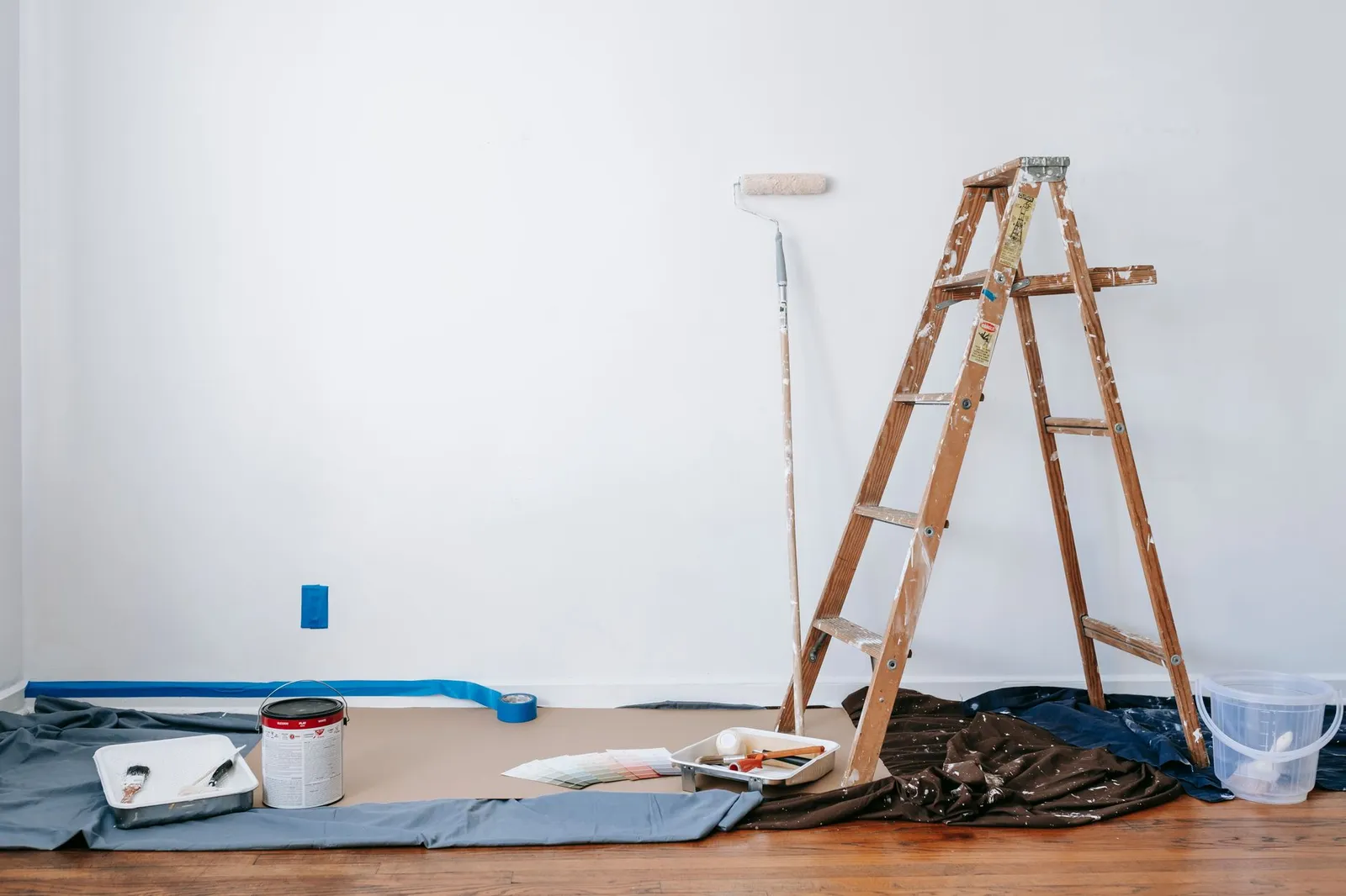 Painter spraying primer on new construction drywall walls inside a Fort Worth home under construction