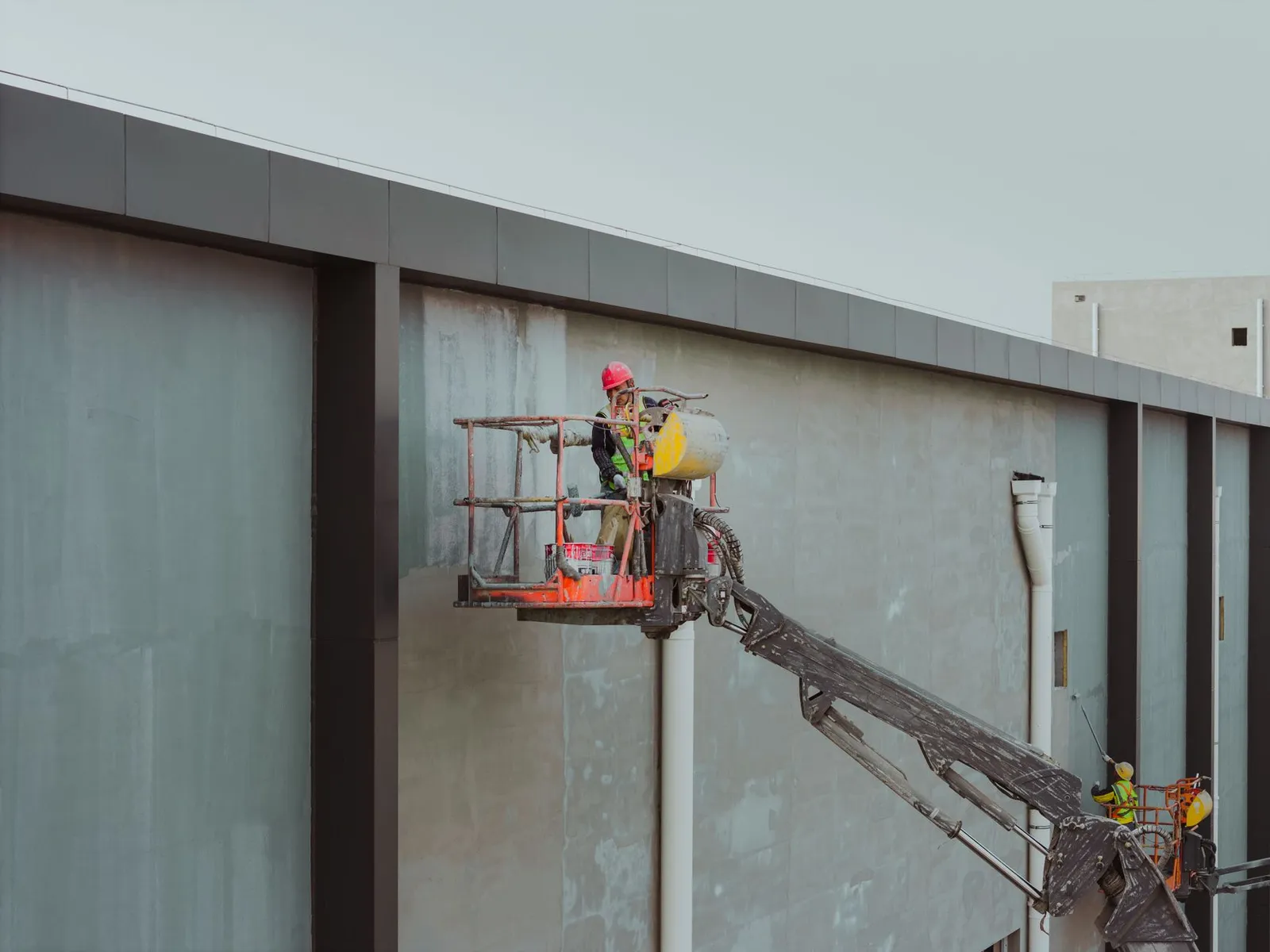 A painting crew working on the exterior of a commercial building on a DFW job site